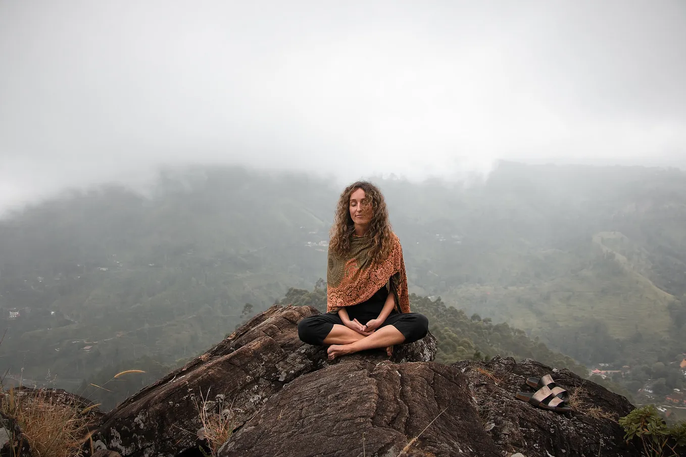 woman meditating on top of a mountian