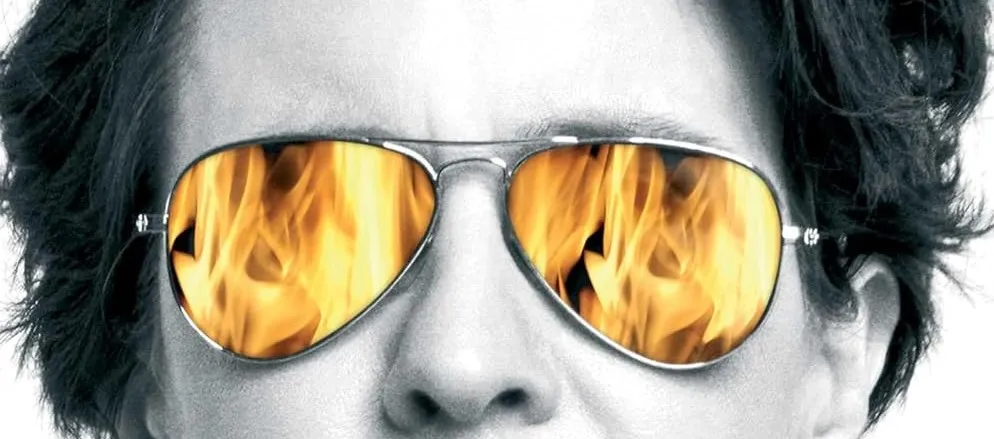 Kara Swisher wearing glasses with flames reflected from her Burn Book cover