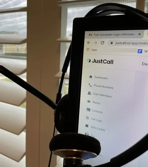 Computer screen with a headphone/microphone attached.