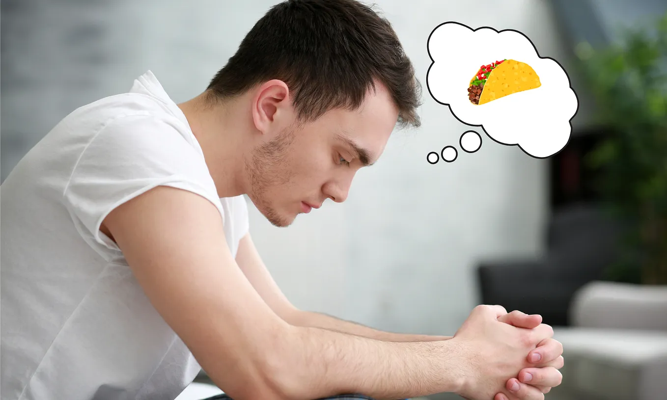 Image of a sad looking man in a white t-shirt looking down with his hands outstreched clasped together in front of him. A cartoon thought bubble contains an image of a taco.
