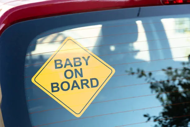 Car rear windshield with a baby on board warning sign