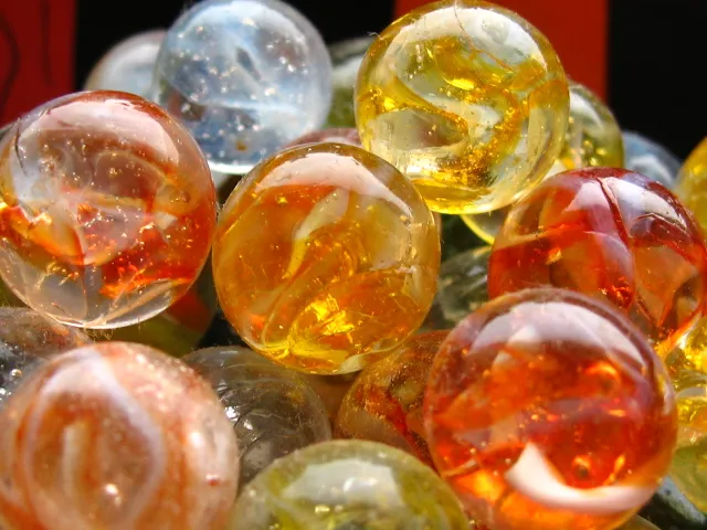 a group of orange, yellow, and blue colored glass marbles