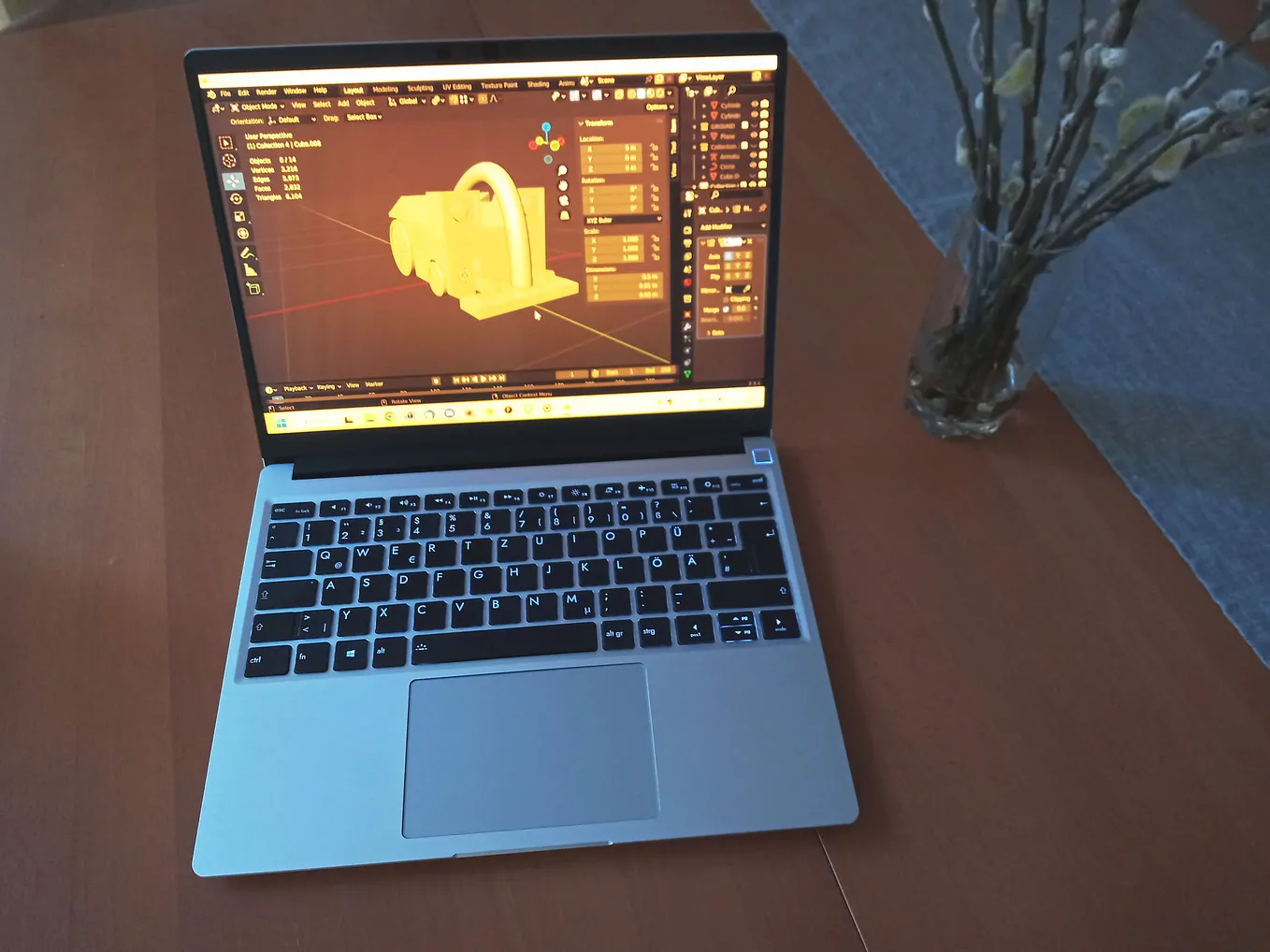 A photo of the Framework laptop on a table running Blender.