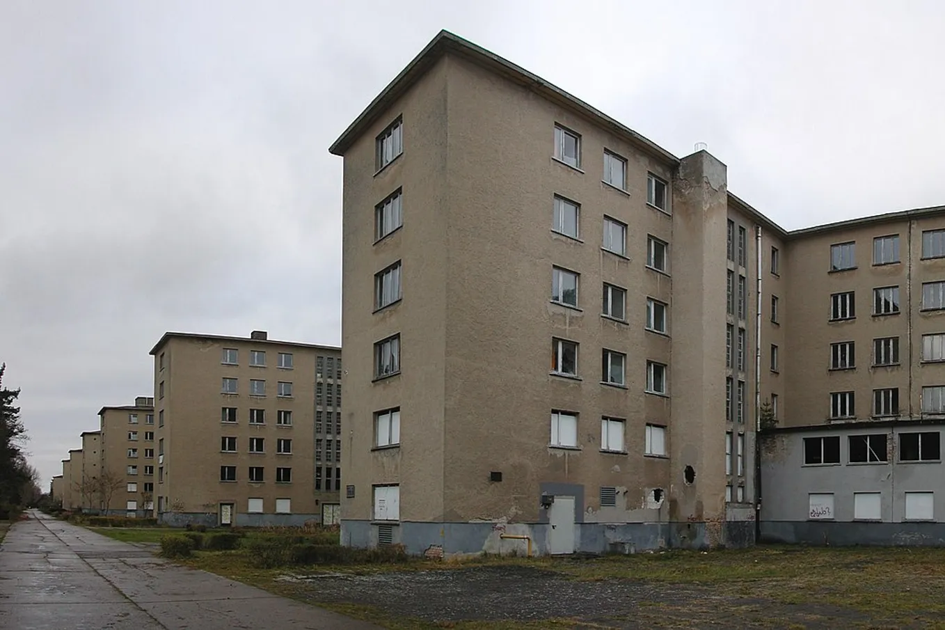 A row of tall apartment blocks stand under a grey sky.