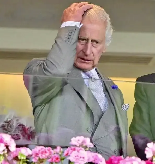 KIng Charles III holding his head