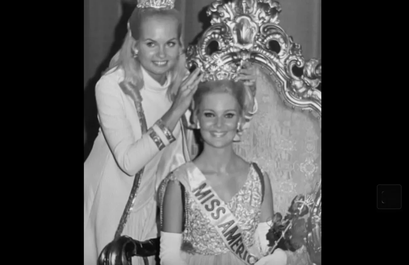 Miss America 1970, Pamela Eldred, sits on her throne to receive her new crown.
