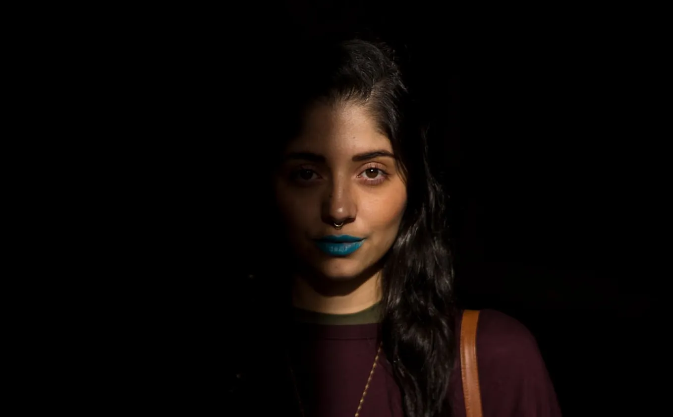 Julian Florez took this photo of a young woman with the right side of her face hidden in shadow.