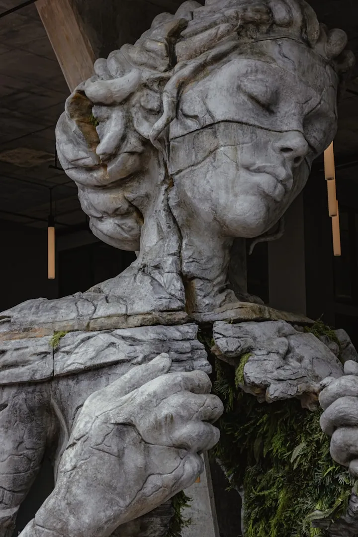 A very damaged, cracked statue of a woman