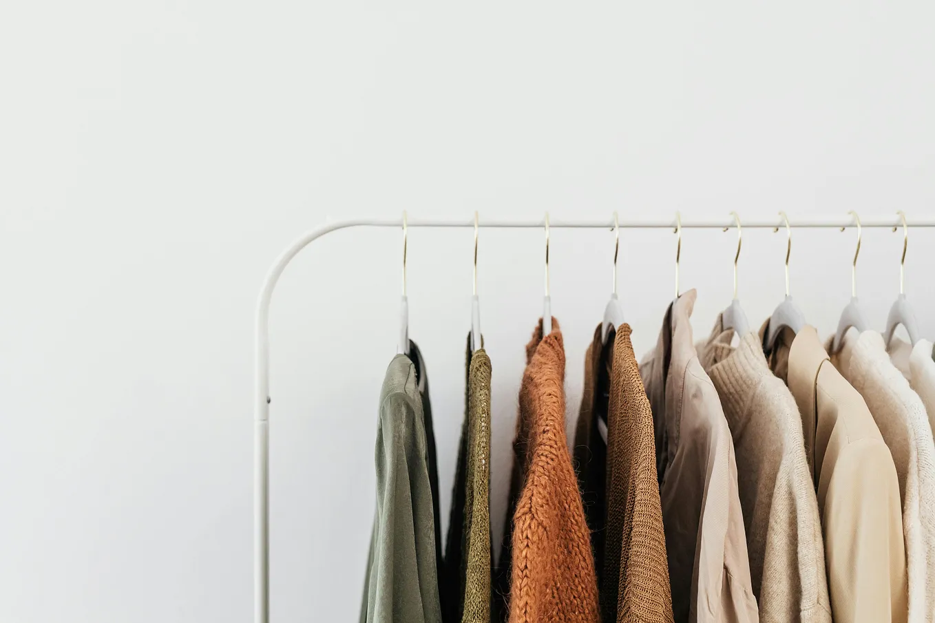 A clothes rack containing shirts hanging on clothes hangers.