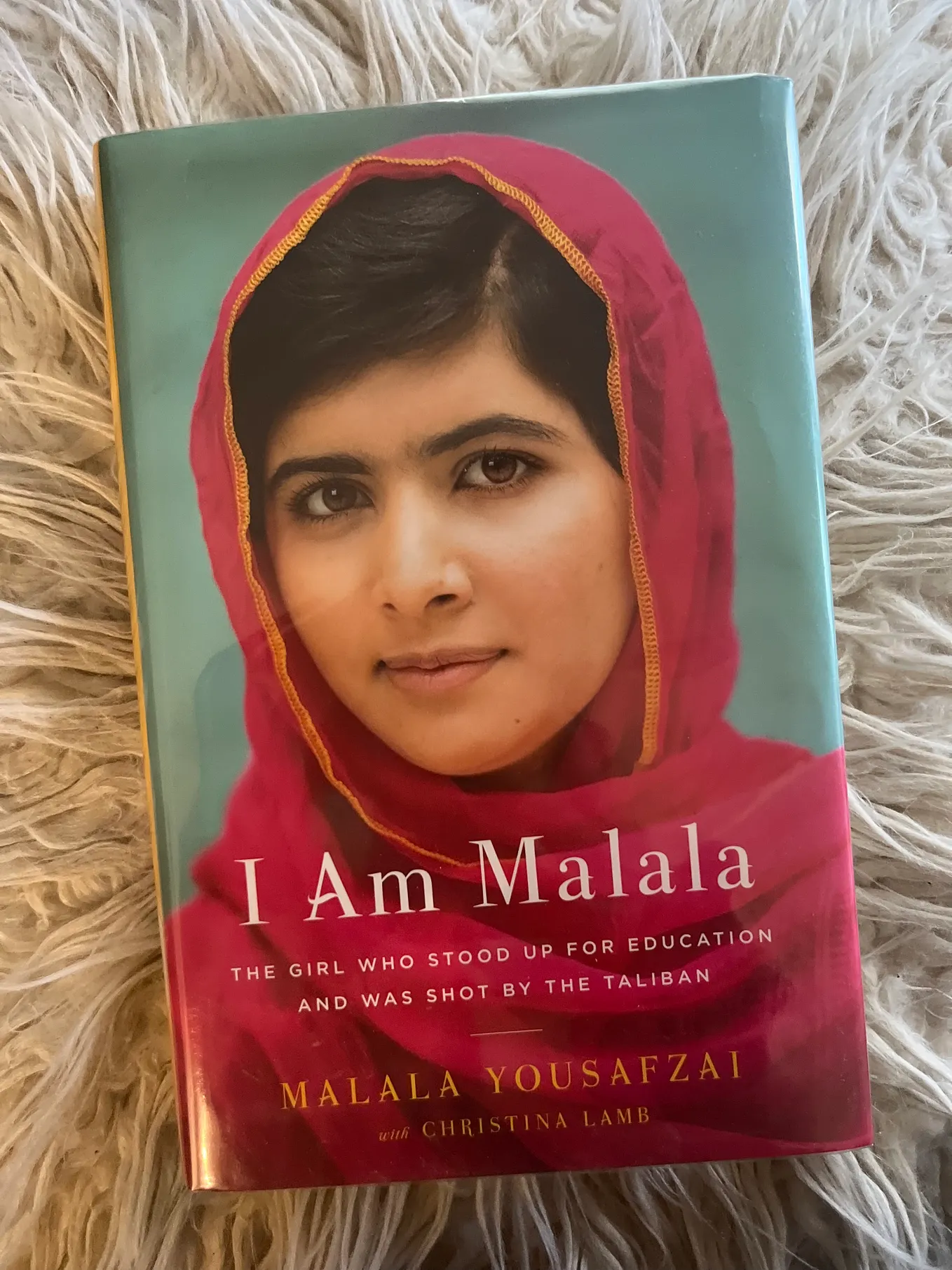 A picture of the book I am Malala with a white textured background.