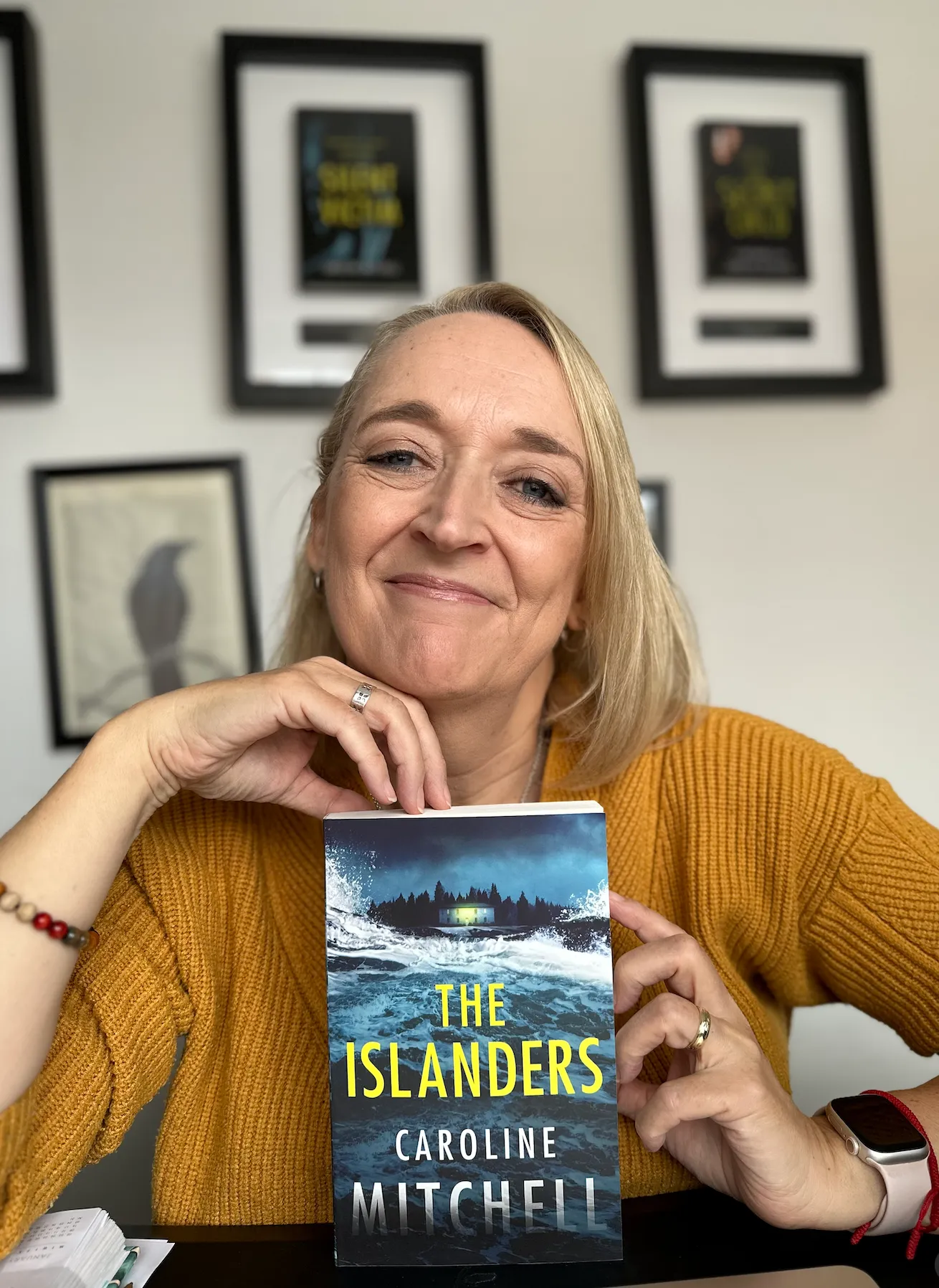 Author Caroline Mitchell holding her book, The Islanders