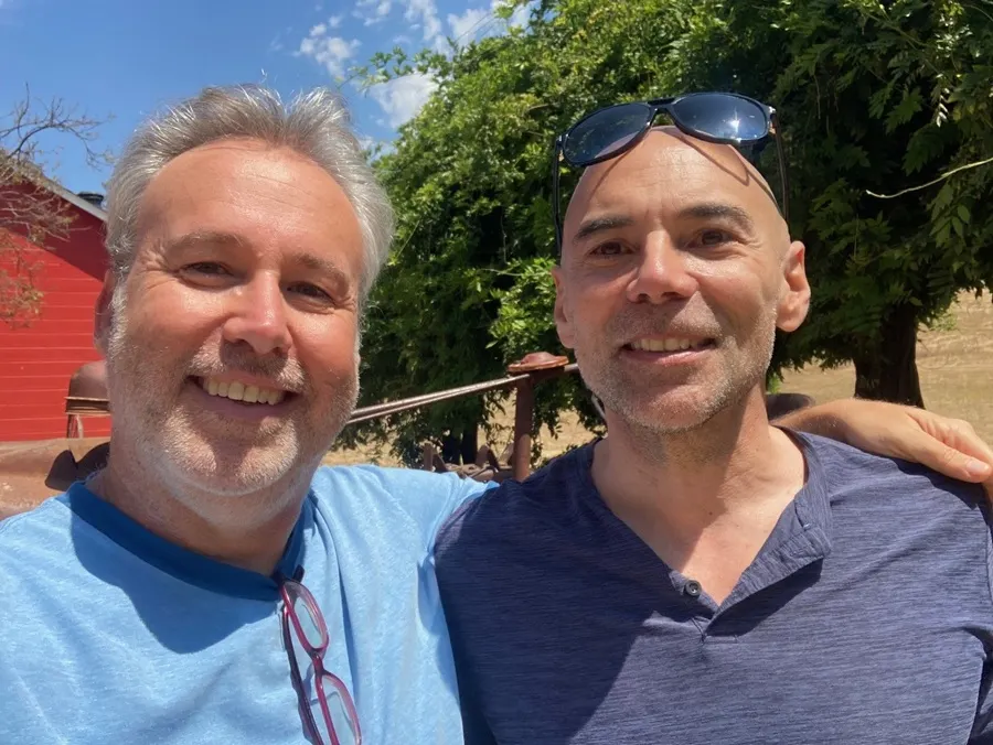 two men embrace and smile