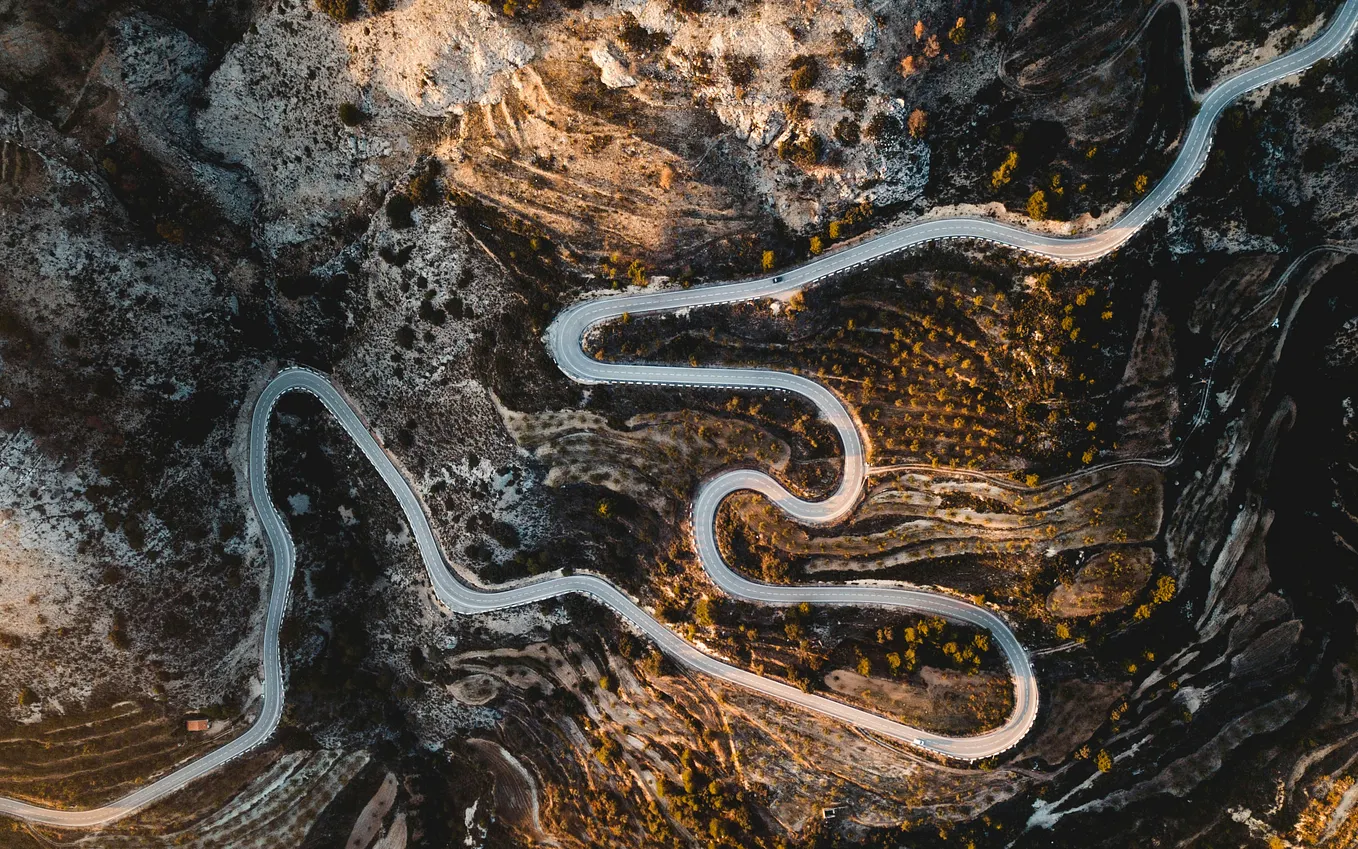 A winding road through valleys from an aerial viewpoint.