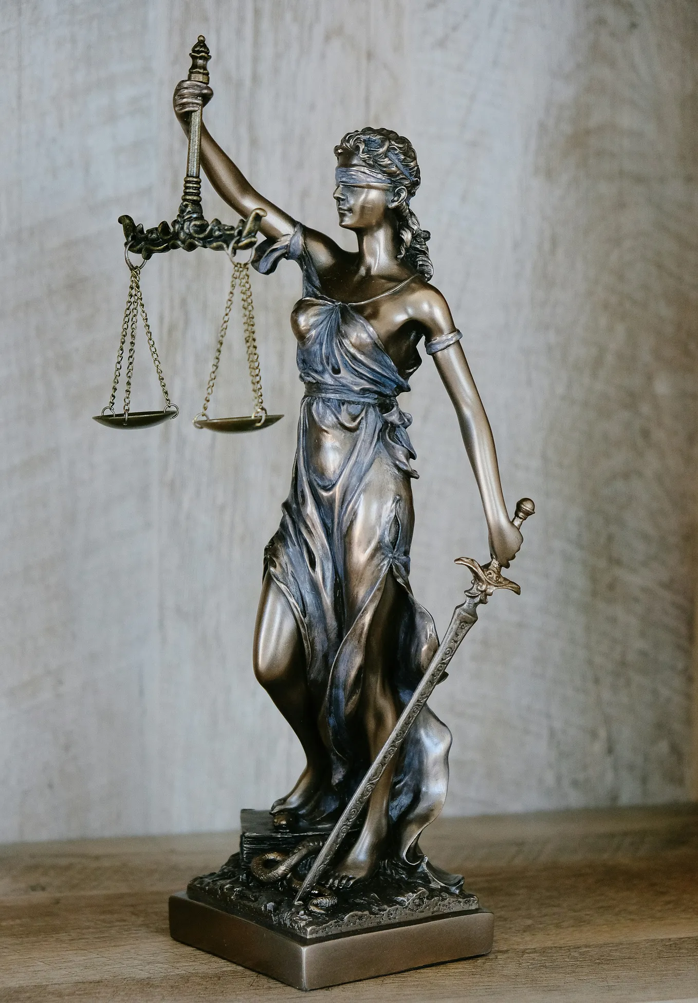 Bronze statue of Lady Justice with a set of scales.