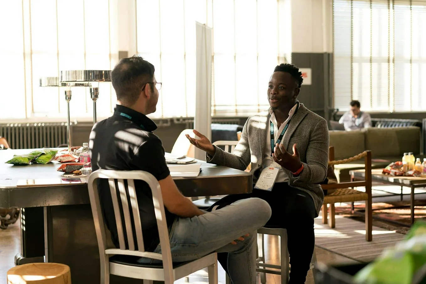 Two men sitting and having a discussion in a casual setting, signifying networking