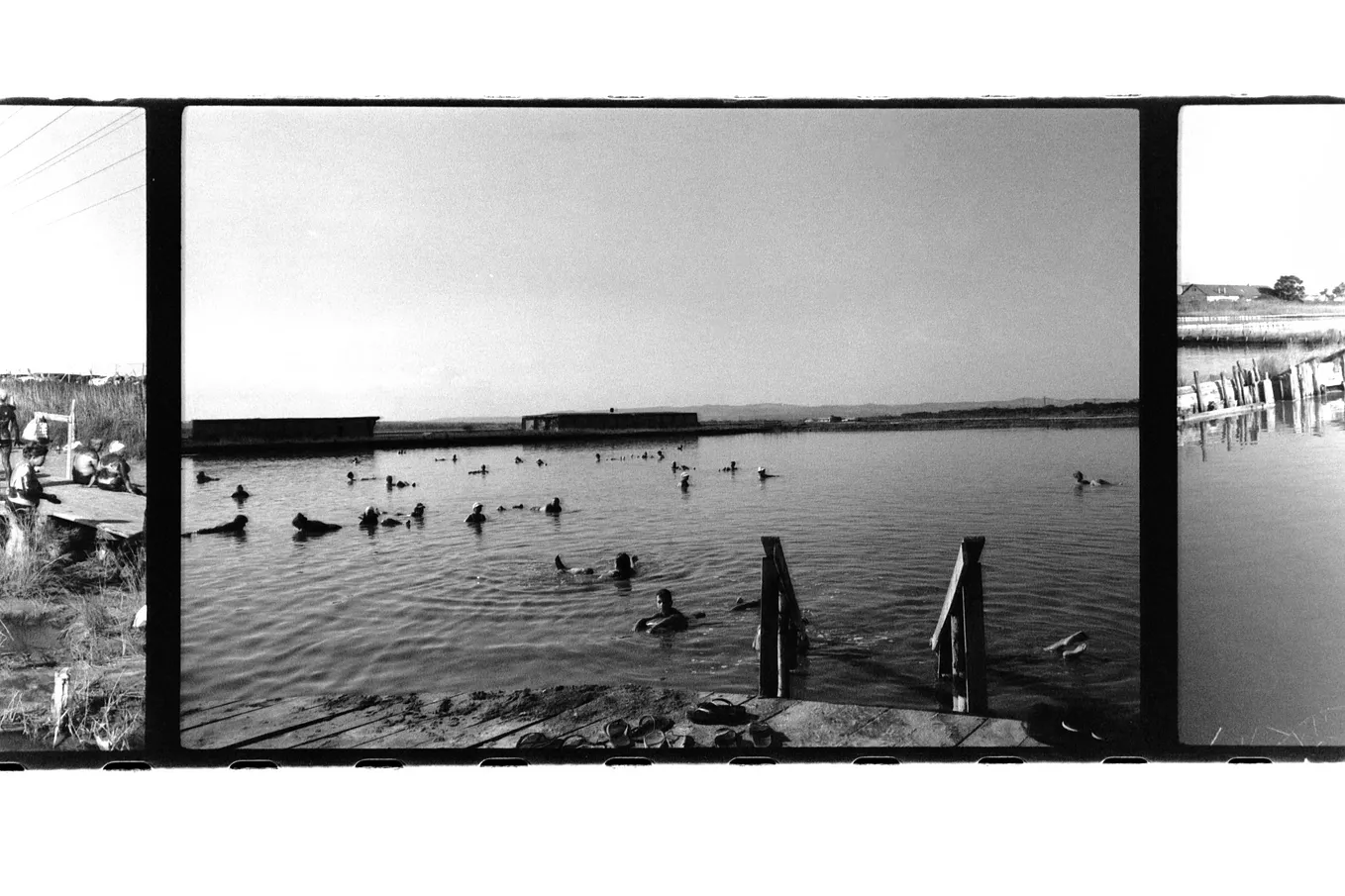 People swimming in a pink salt lake in Burgas, Bulgaria, shot on a blacka and white film roll.