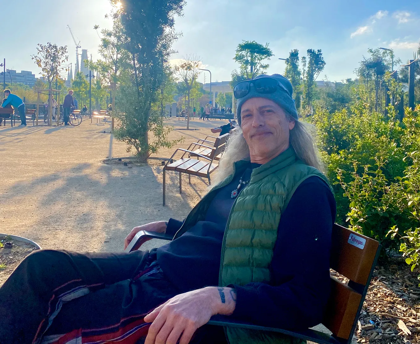 The author sitting on a park bench in Barcelona with Sagrada Familia in the background.