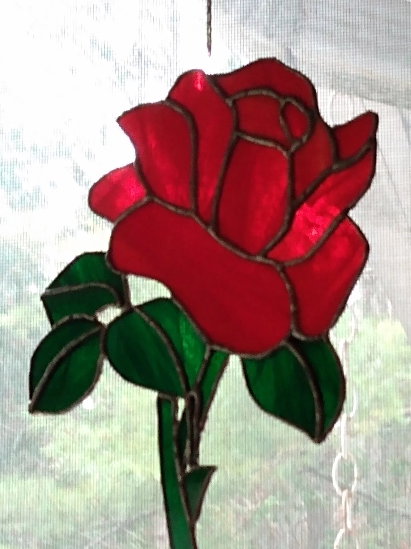 A hanging stained glass red rose.