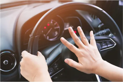 Picture of driver pressing car horn.