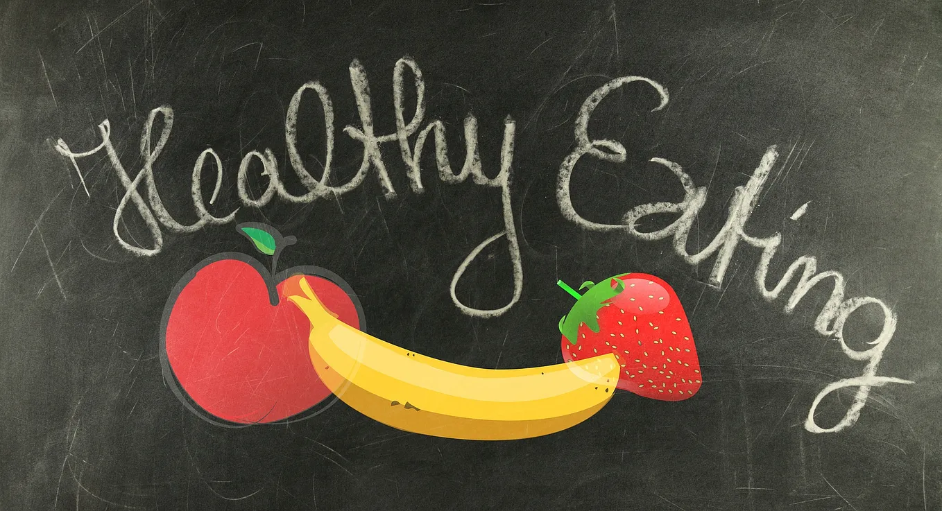 Blackboard — healthy eating — banana and 2 strawberries