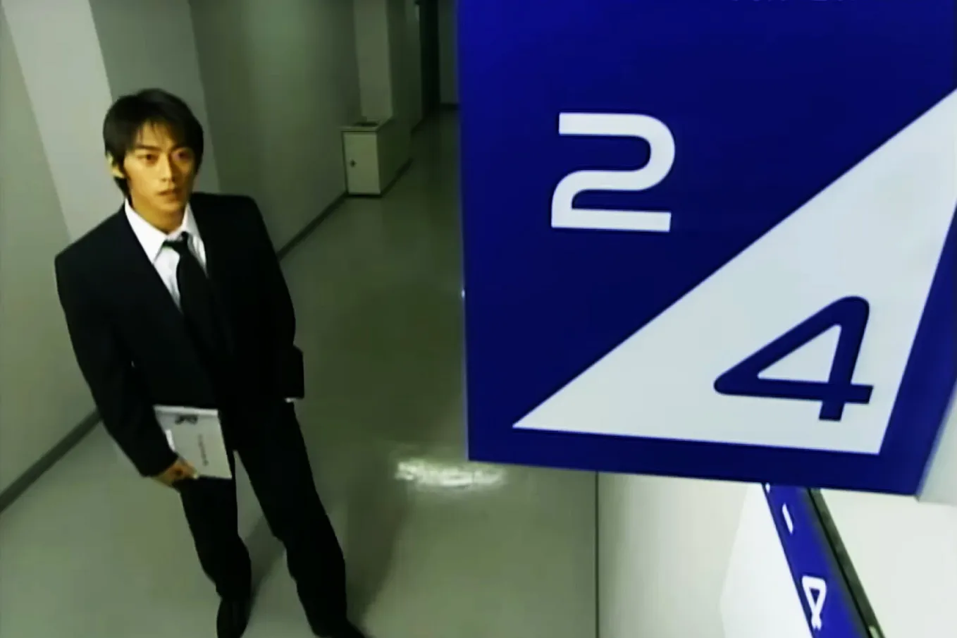 A nervous Eikichi Onizuka stares at the sign for Class 2–4.