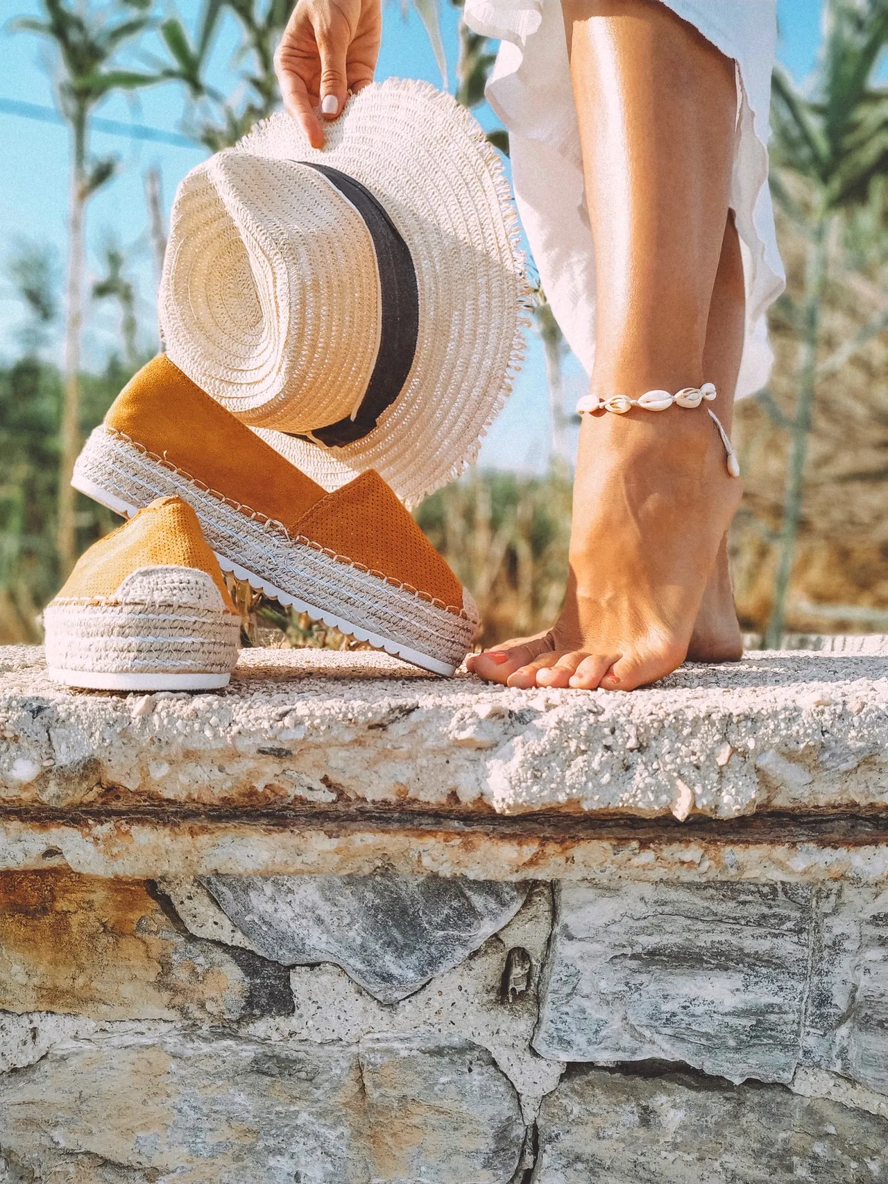 A woman wearing an anklet made out of cowrie shells