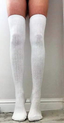 Posy wears white over the knee socks and stands on tip-toe