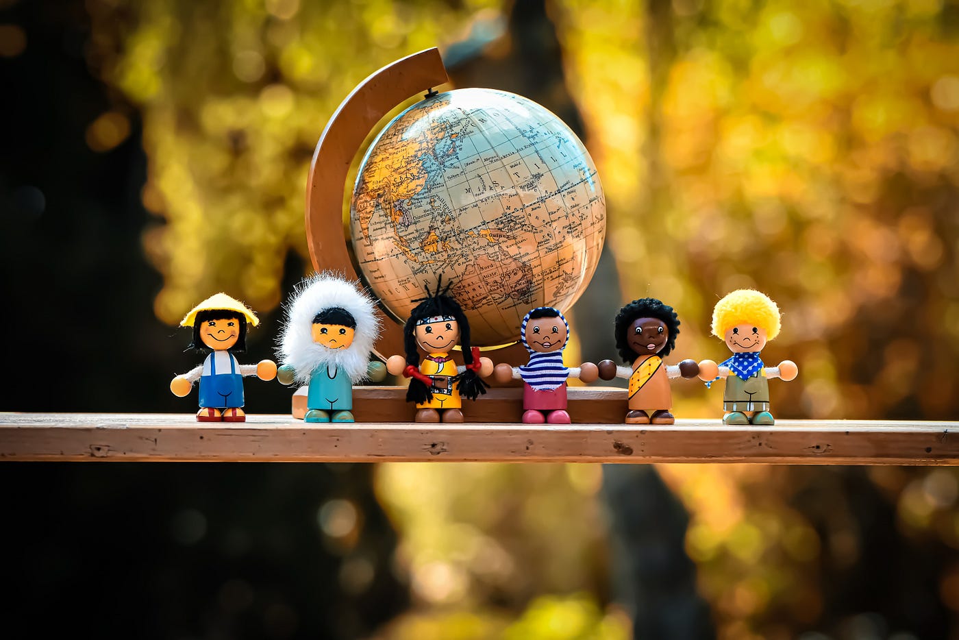 all different ethnicities in lego form surrounding a desktop globe.