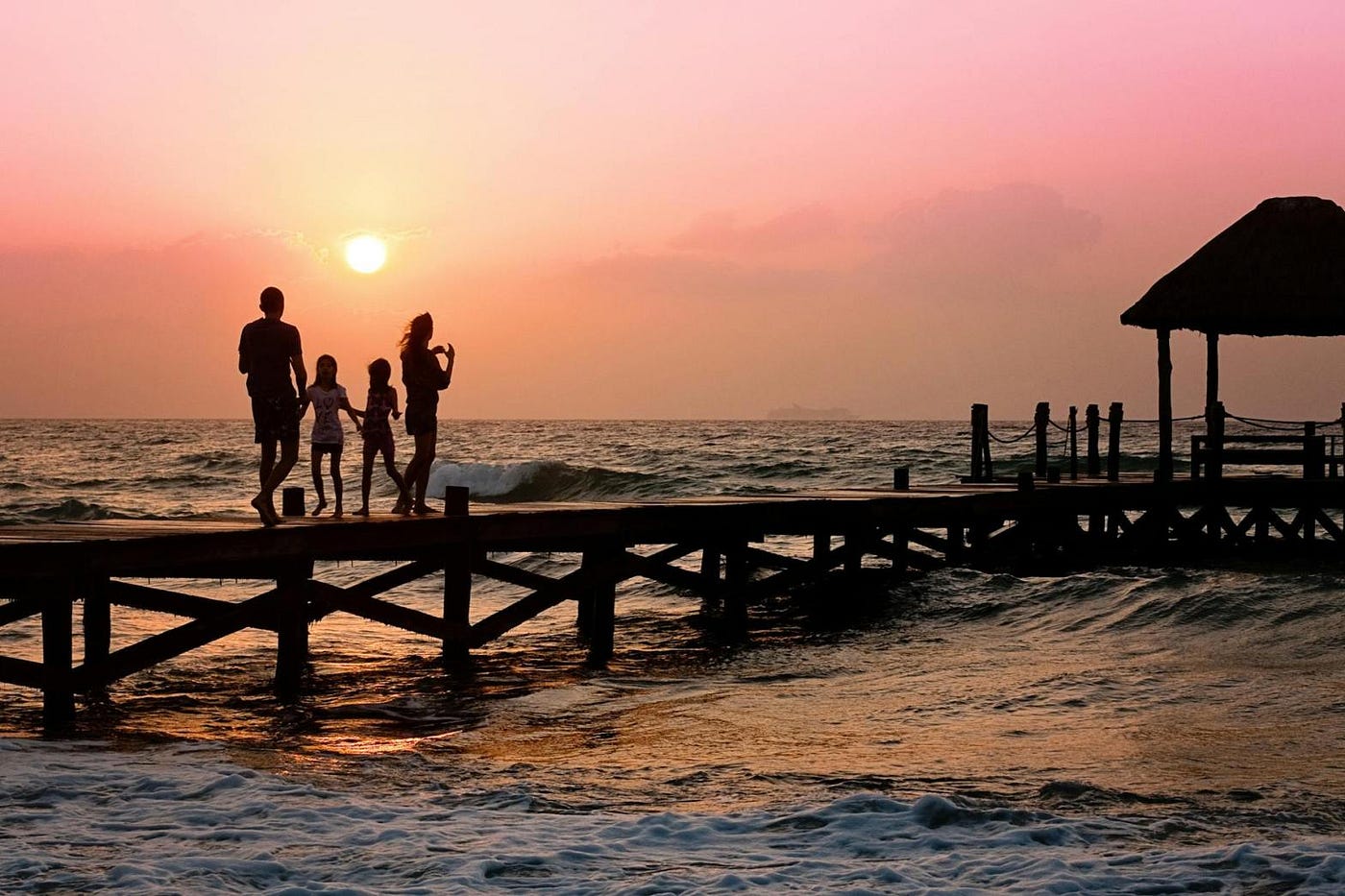 Mickey Markoff 2023 — wife, husband, children walking along pier at sunset over ocean posted on article on military spouses