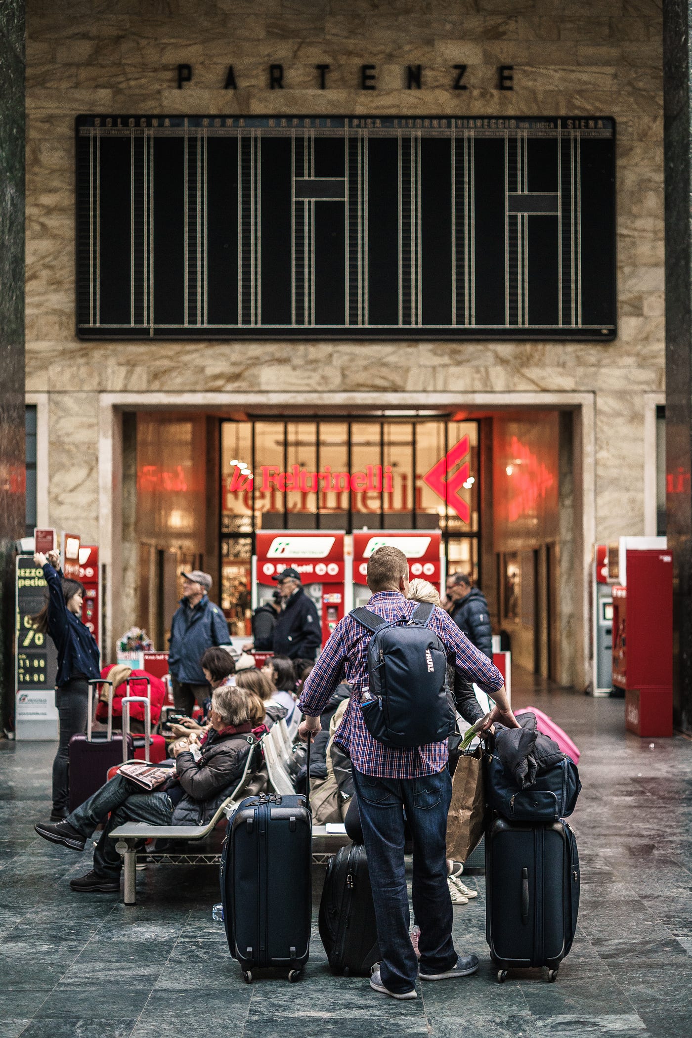 A group of people standing next to a train station photo – Free Italia  Image on Unsplash