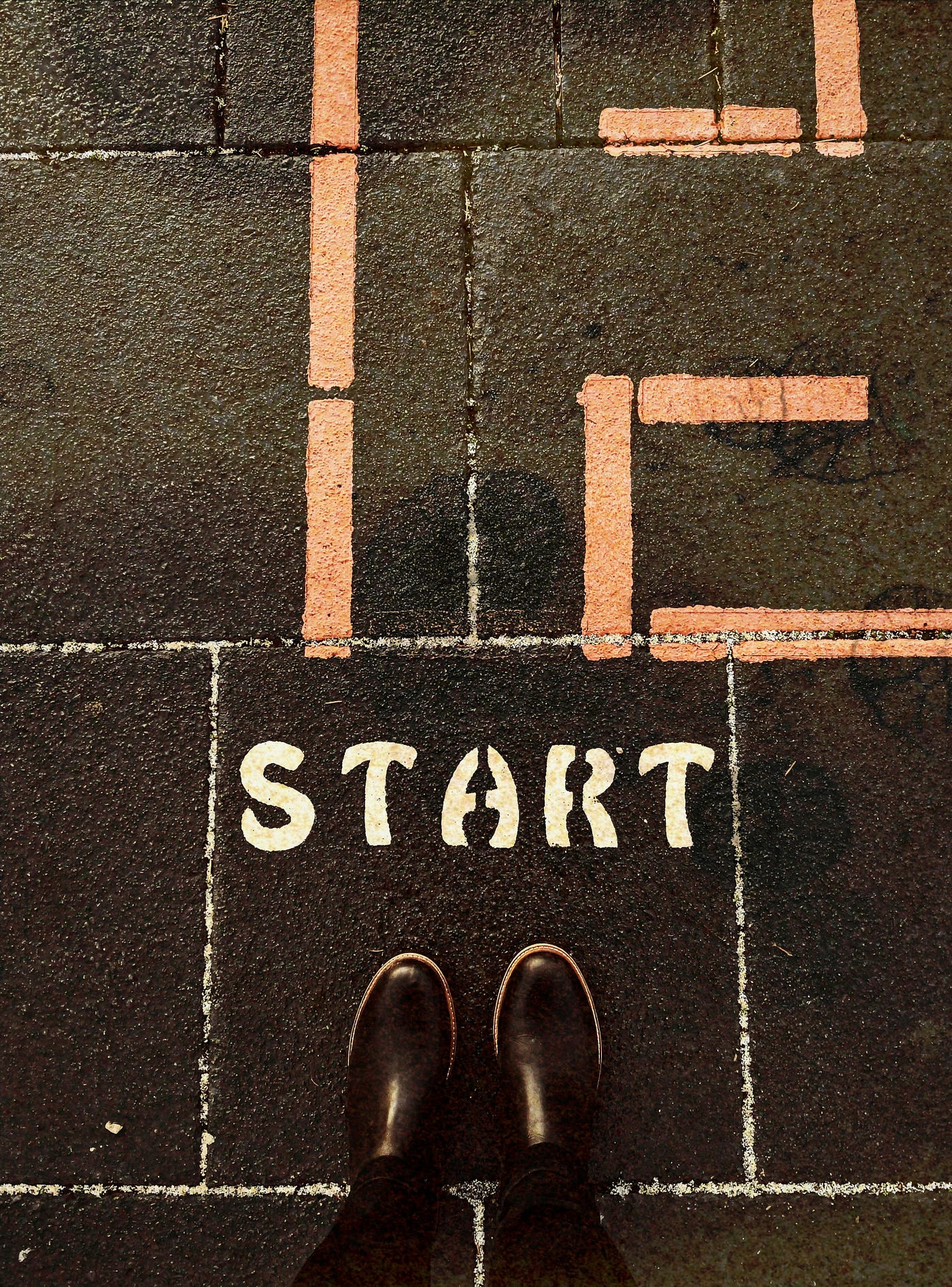 https://unsplash.com/photos/a-person-standing-on-a-sidewalk-with-the-words-life-start-painted-on-it-s3JEcQDw0FY