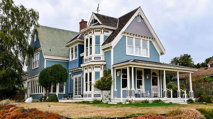 Image of a victorian era home with blue exterior walls.