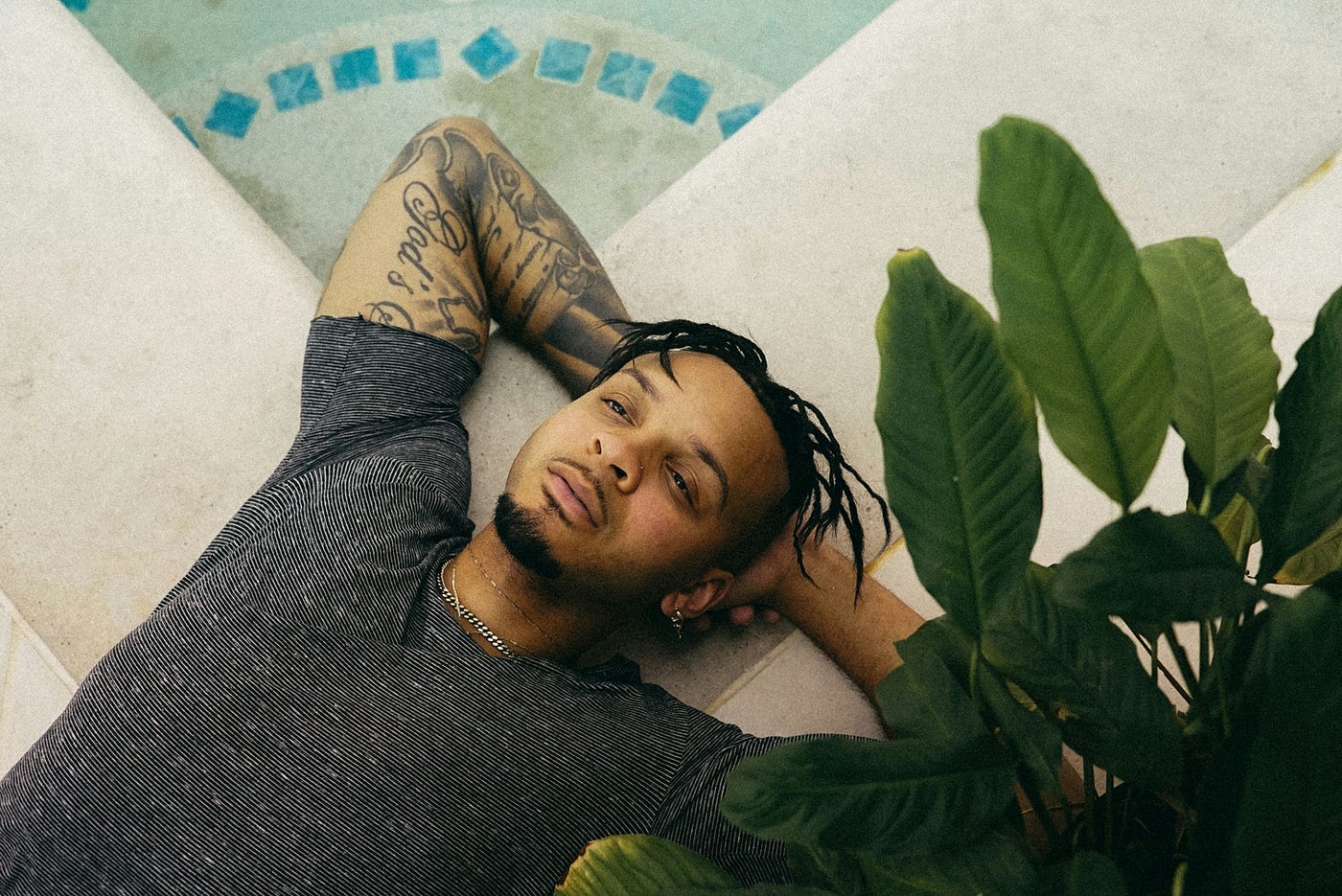 한 남자가 자라는 식물 옆에서 휴식을 취하고 있다