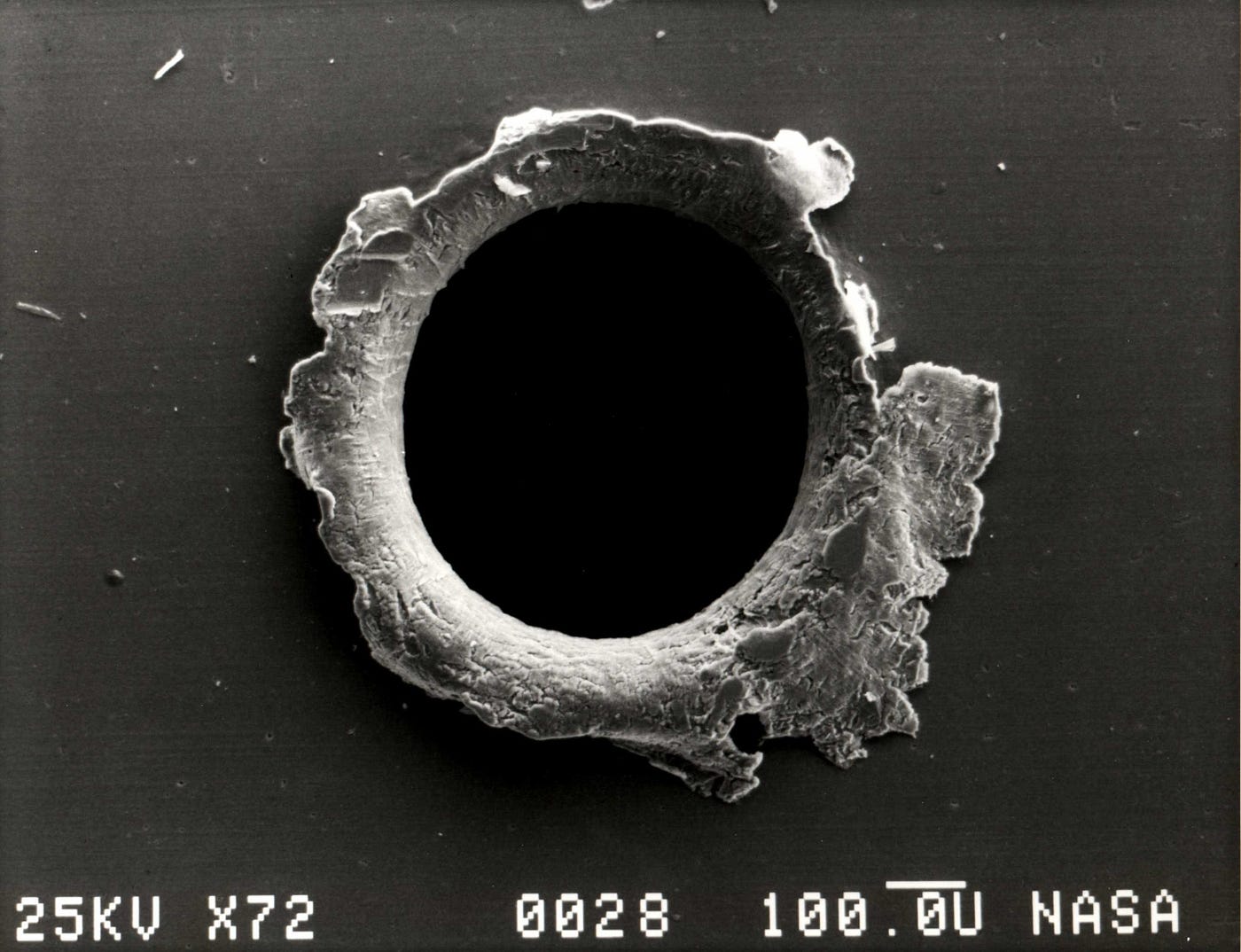This image shows a hole that was made in the panel of NASA’s Solar Max satellite by a micrometeoroid impact. Although this hole likely arose from simply a piece of dust, the “v²” term in the equation for non-relativistic kinetic energy (½mv²) can become very large, very quickly. For particles that move close to the speed of light, the effects of kinetic energy, or energy-of-motion, become even more severe when relativistic effects are taken into account. (Credit: NASA)