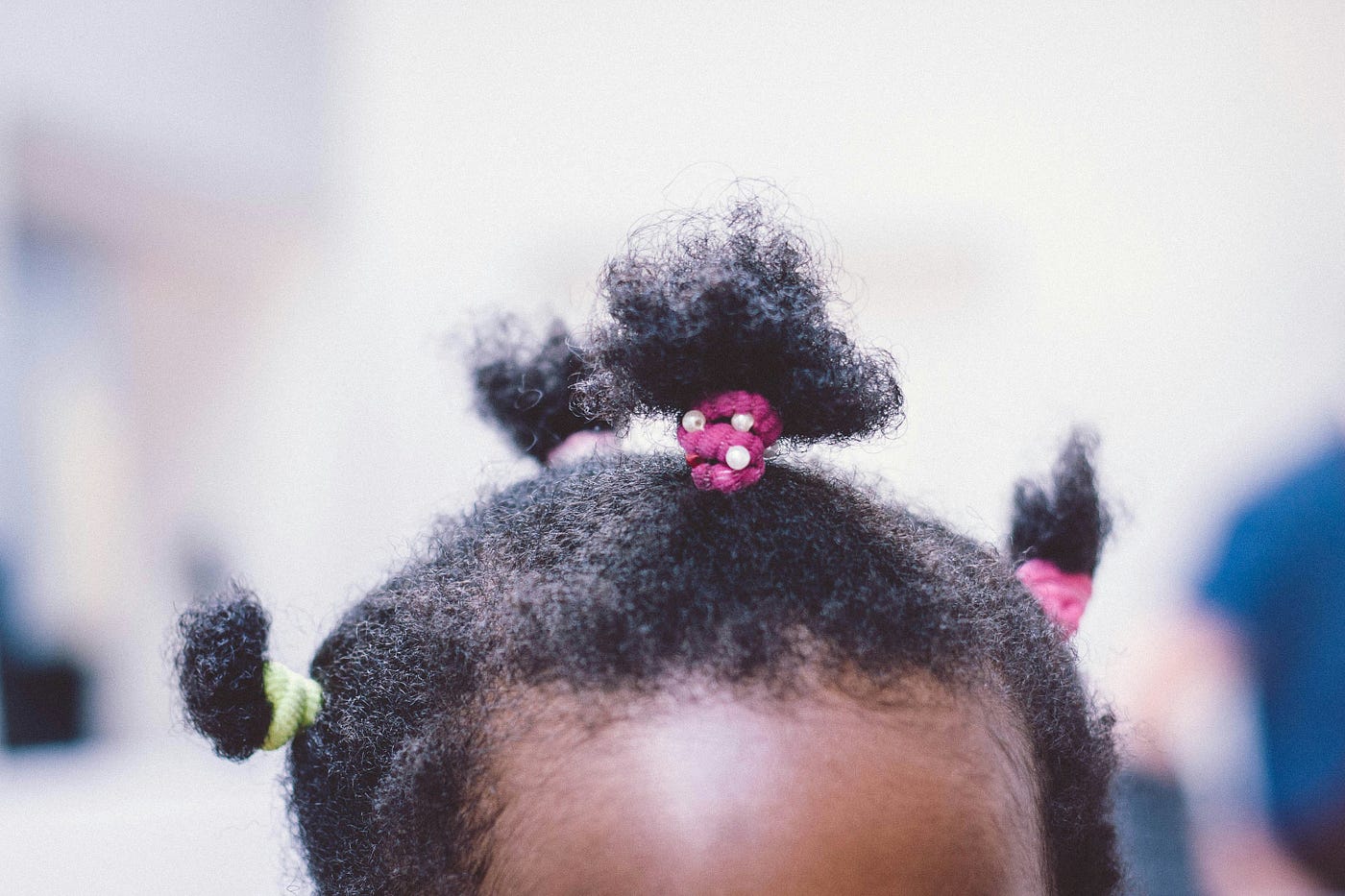 A very young black child’s hair is seen as the photo extends from low forehead up. She has three pigtails. A new test uses a strand of hair to rule out autism.