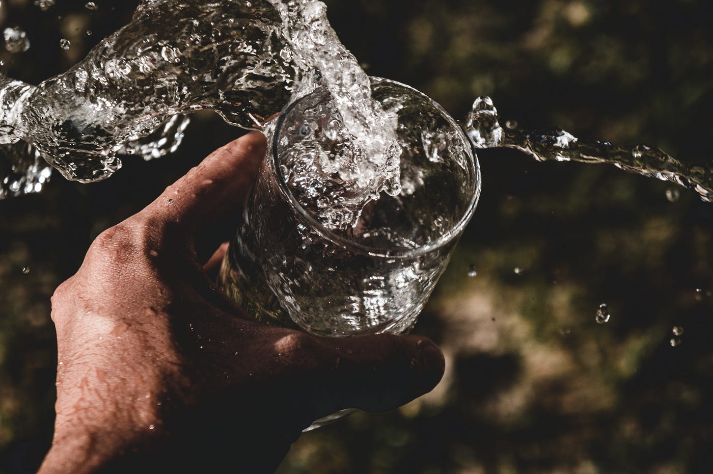 A hand extends from the bottom of the image to shake a glass of water. The water is splashing out. It takes 18 to 254 days to form a new habit. The study also concluded that, on average, it takes 66 days for a new behavior to become automatic.
