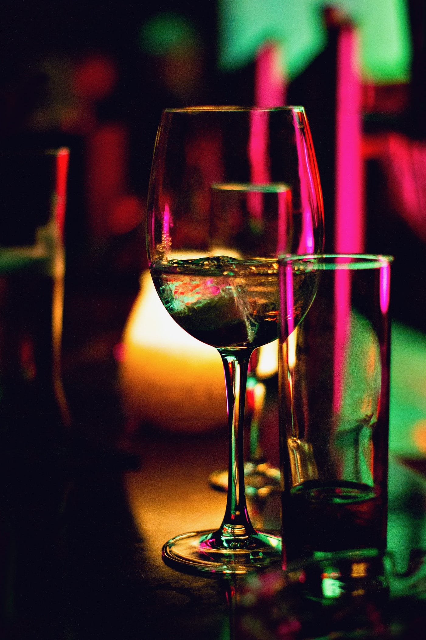 A glass of white wine (in close-up) in a darkened bar. Even moderate consumption — up to one standard drink daily for women and up to two for men — is linked with a higher breast cancer risk, particularly estrogen and progesterone-driven breast cancer.