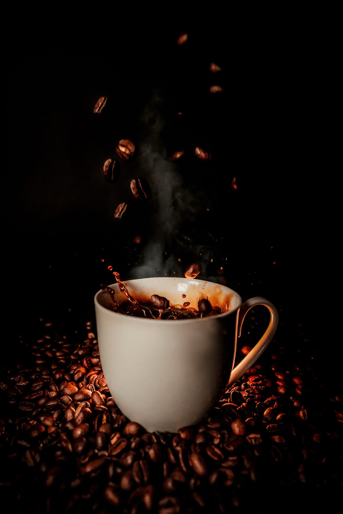 Several coffee beans drop from above into a cup of coffee. Black background. The brain’s default mode network is active when we are not focused on the outside world and our brains are in a wakeful rest. Examples include daydreaming and mind-wandering.