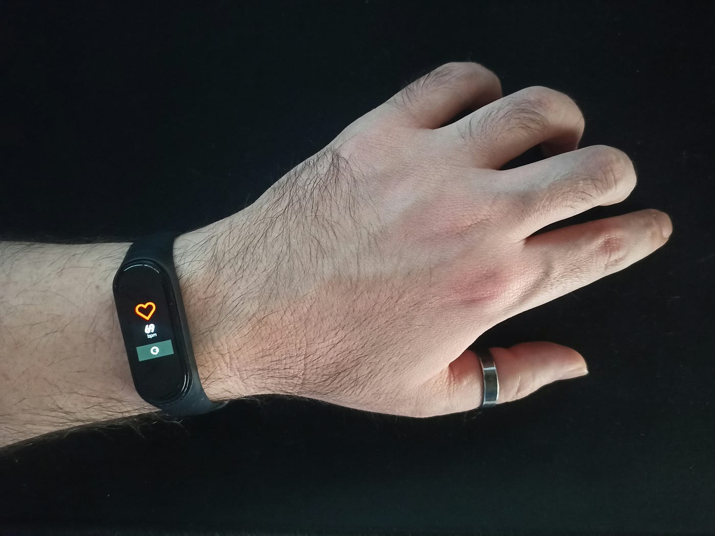 A fitbit on a wrist tracks heart rate during exercise.