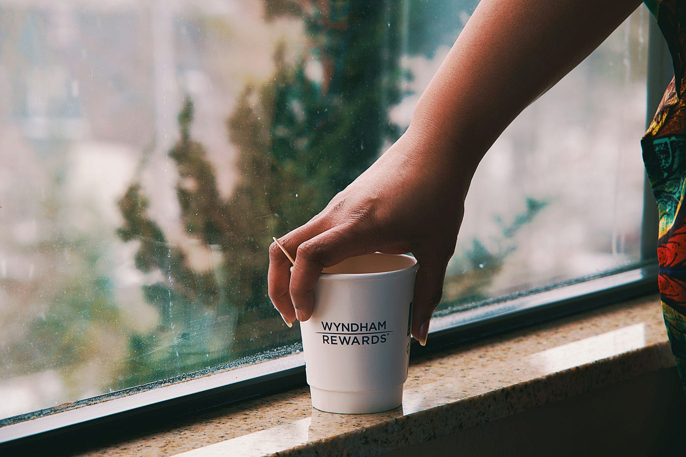 햇살이 비치는 창가에 따뜻한 커피잔을 든 손, 아늑한 분위기.