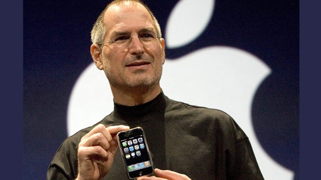 Steve Jobs with the 1st iPhone released in 2000s