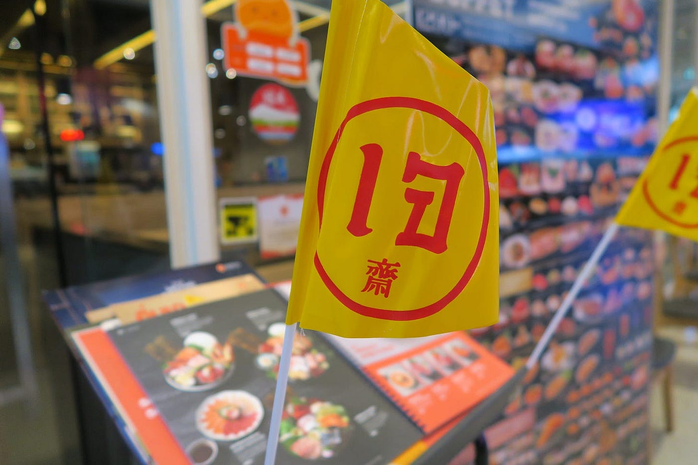 Je flags in front of a Japanese restaurant in Hua Hin advertise their vegan menu.