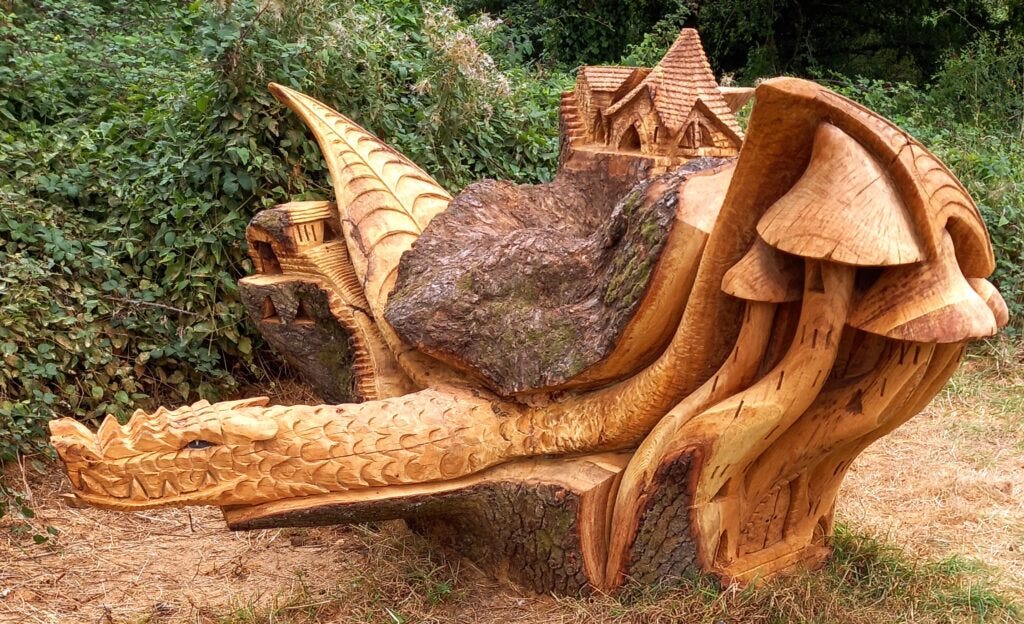 Intricate image of tree carving showing a dragon with wings, some buildings and some toadstools, to illustrate post