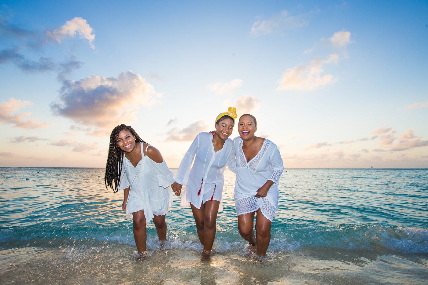Three Black women, dressed in white, smile as they emerge from the ocean. New breast cancer screening guidelines from the US Preventative Task Force may prevent an estimated 1.8 breast cancer deaths per 1,000.