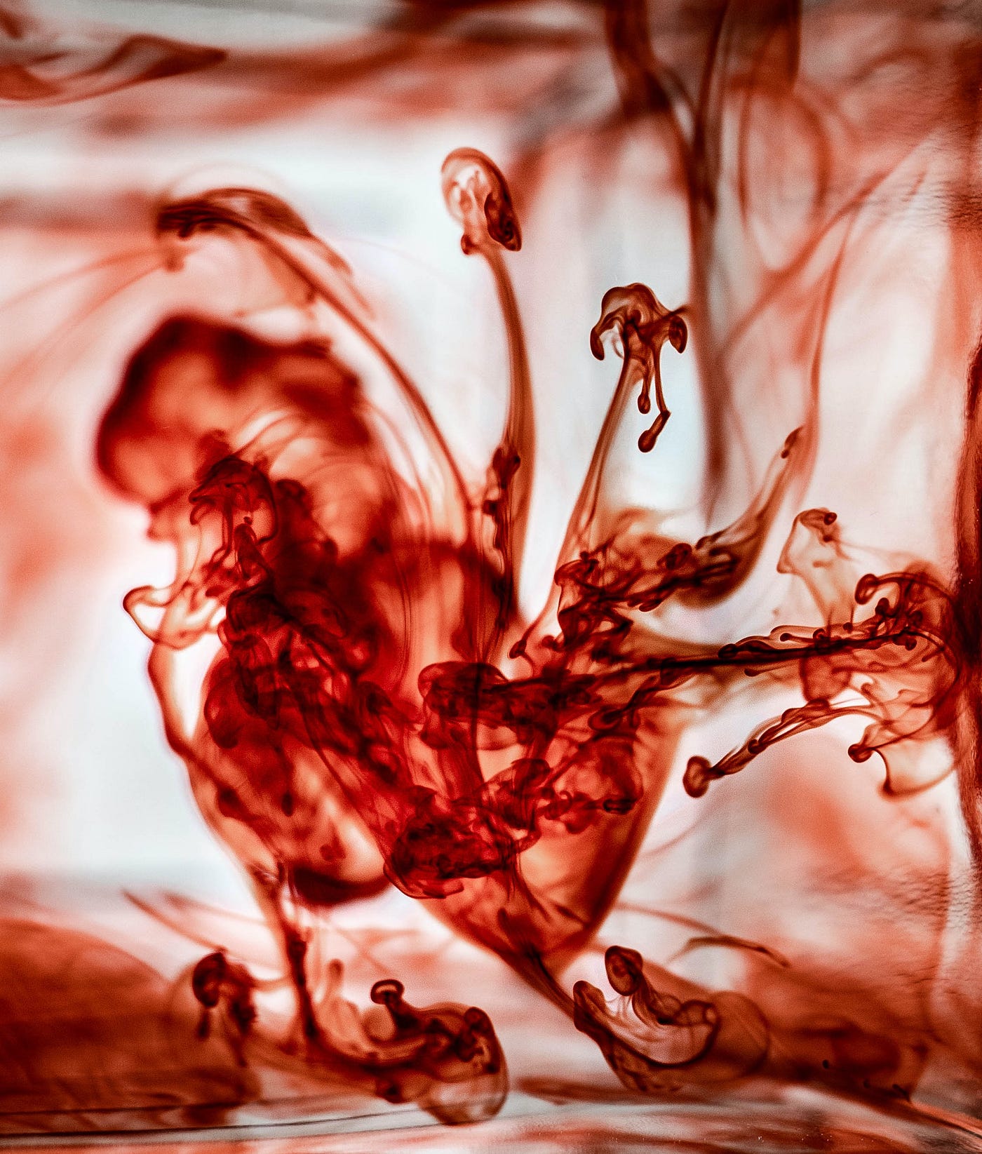 A blood-red fluid splashes in all directions of the image. Why does red wine cause headaches for some? Is it sulfites? In short, no. Those who have an allergy to sulfites tend to develop hives and difficulty breathing, not a headache. In addition, white wines typically have more sulfites than reds.
