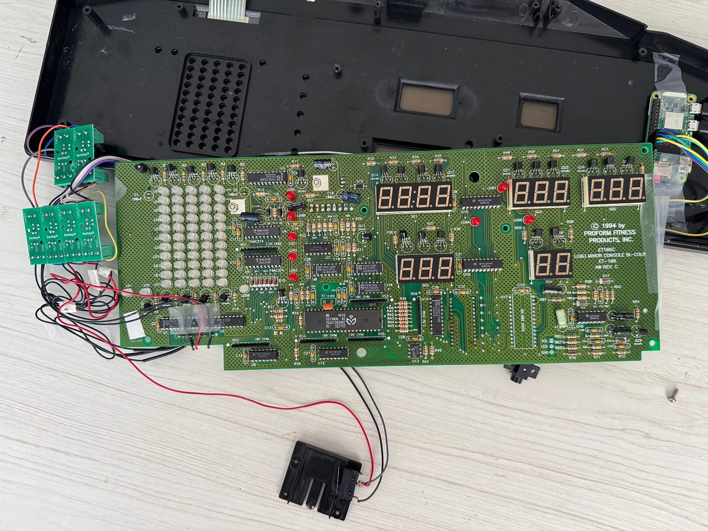 Plastic case top with membrane keyboard, treadmill display/controller board. Just look at that beautiful wire bundle in lower left. Nothing scotch tape can’t handle.