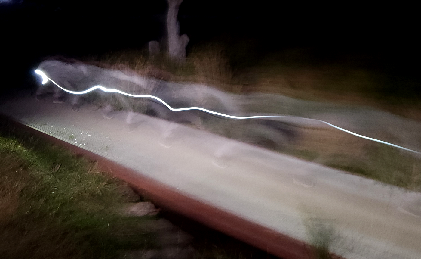 Long exposure of Ms6 running across a boardwalk with a torch