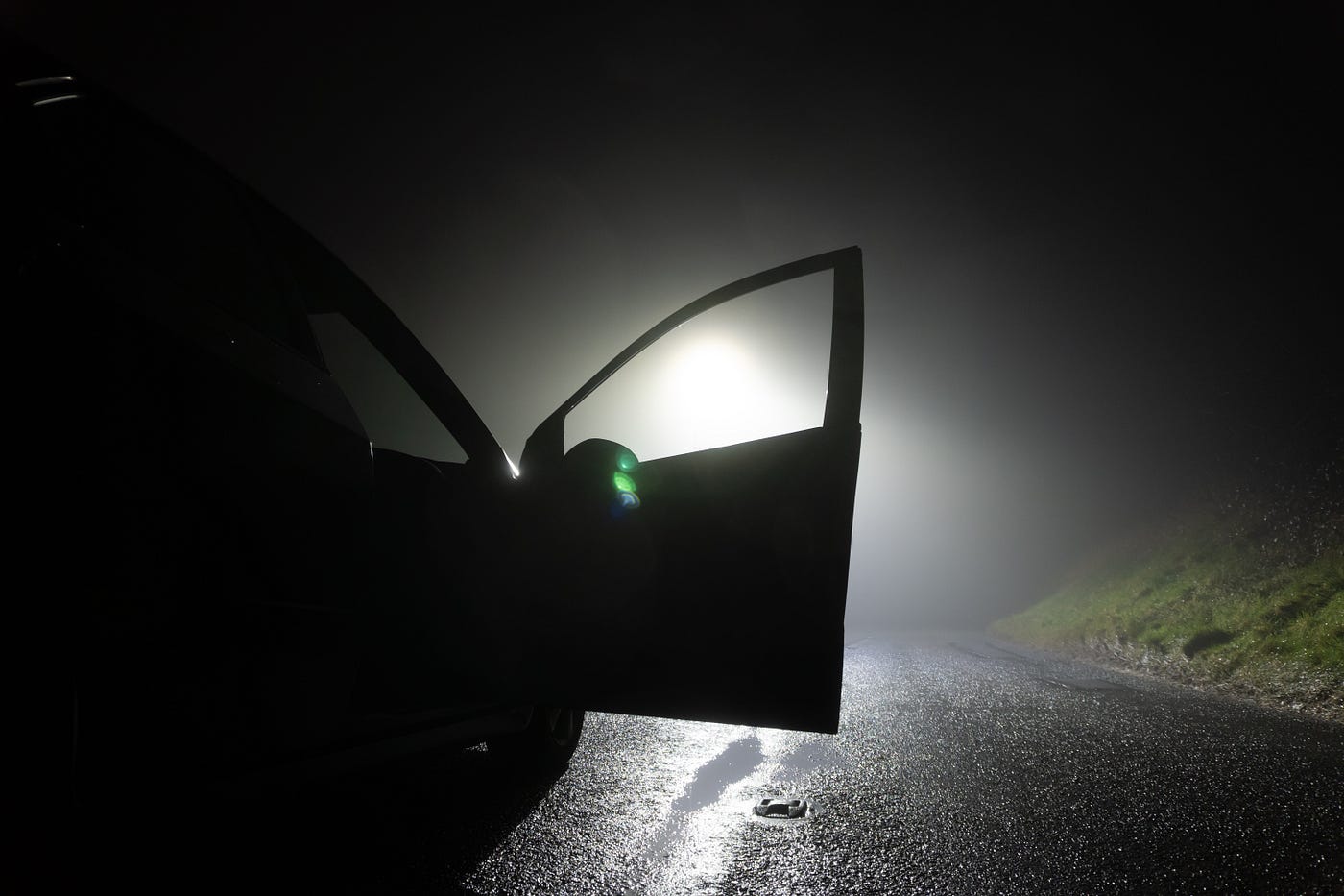“ A car parked, with door open, on the side of the road, underneath a street light. On a foggy winters night “ | by Raggedstone | Shutterstock