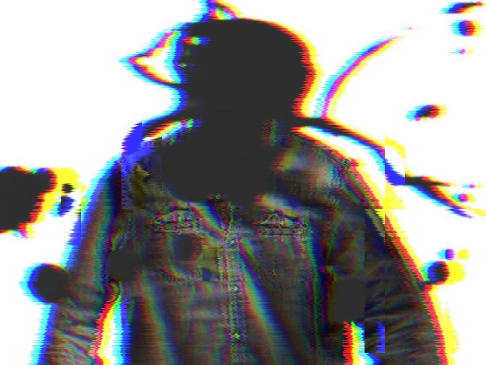 a glitchy photograph of a black shirt with a giant black ink splash where the persons head might be