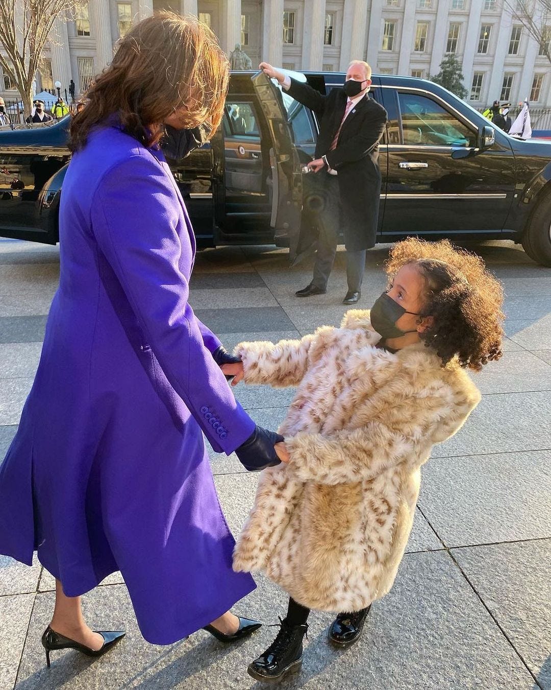 Harris holding Amara’s hands in front of a limo; the driver is holding the back door open.